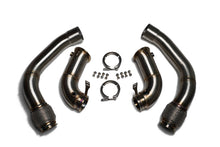 Two pairs of stainless steel downpipes with braided flex sections, V-band clamps and bolts on a white background