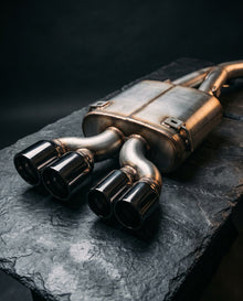 Stainless steel rear silencer with four black-chrome tips on dark slate