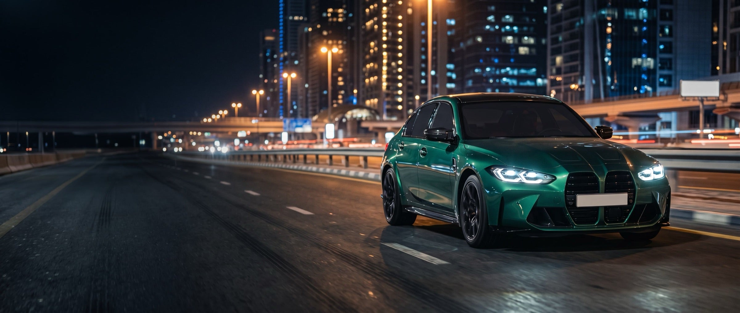 Green sports saloon on a Dubai highway at night